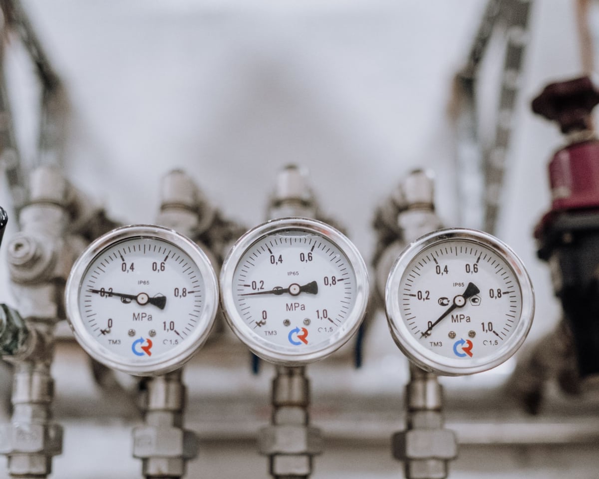 Trois manomètres de précision alignés sur une installation industrielle — instrumentation de mesure